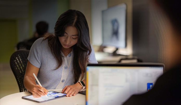 Una estudiante universitaria usa el Apple Pencil para tomar notas en un iPad en un laboratorio de tecnología