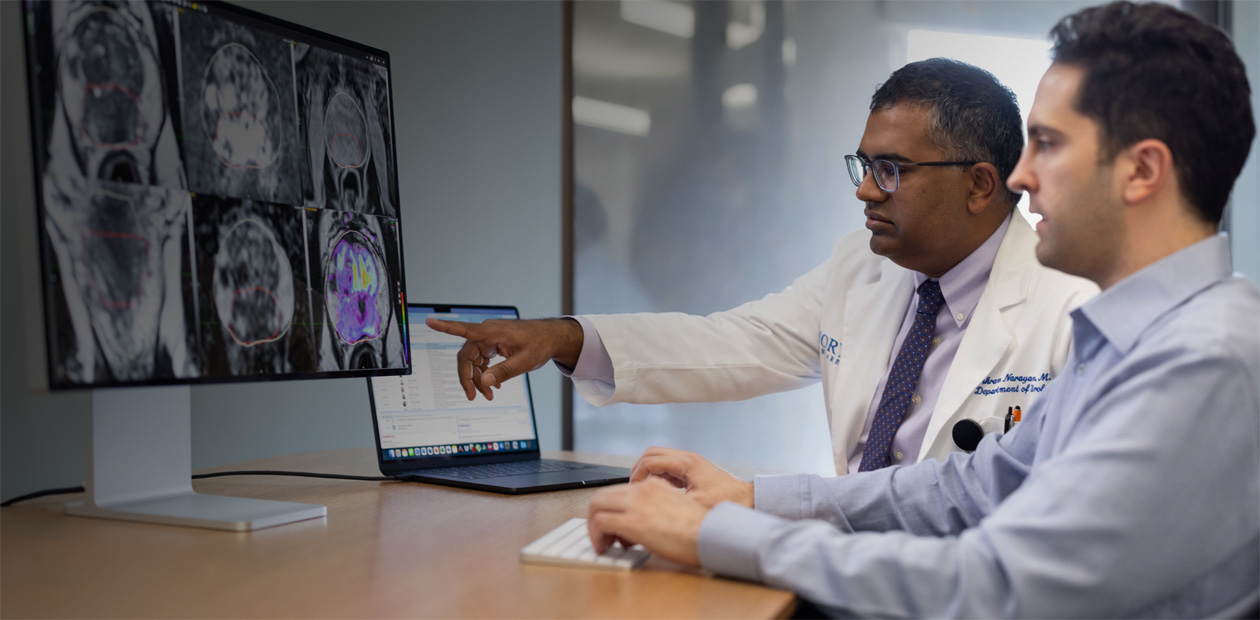 Deux médecins observent des radiographies sur un iMac.