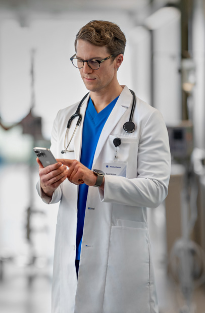 À l’hôpital, un médecin consulte son iPhone pour examiner les progrès d’une patiente.