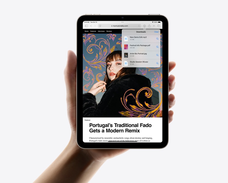 Mão a segurar o iPad mini na vertical a mostrar downloads no Safari.