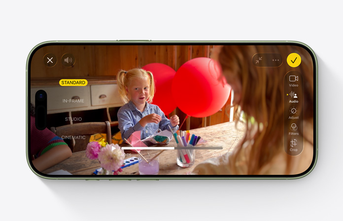 iPhone 17, esikülg, Audio Mix funktsiooniga video lapsest, kes mängib laua taga õhupallidega